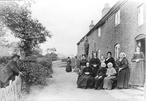 Image: group of villagers outside the alms houses known as The Barracks
